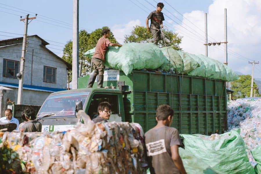 Workers offload bags of Mountain Plastic recyclable bottles into the Himalayan Life Plastics plant