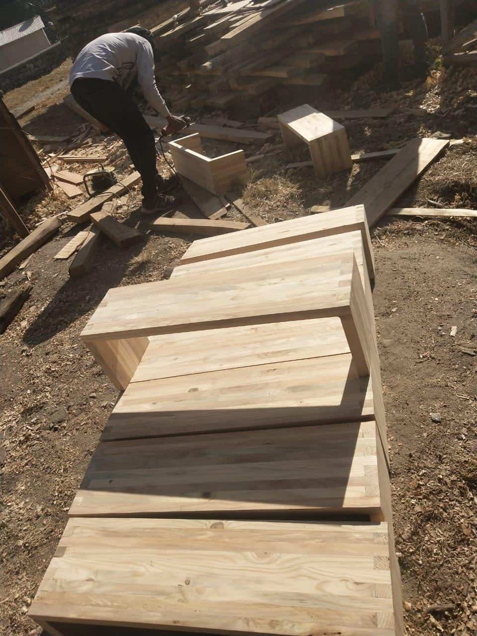 A carpenter builds benches for the students to sit on during the upcoming school year in Yangri