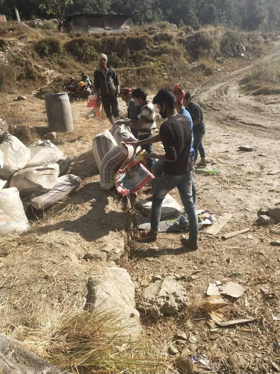 Workers lift bags of cement for the new school