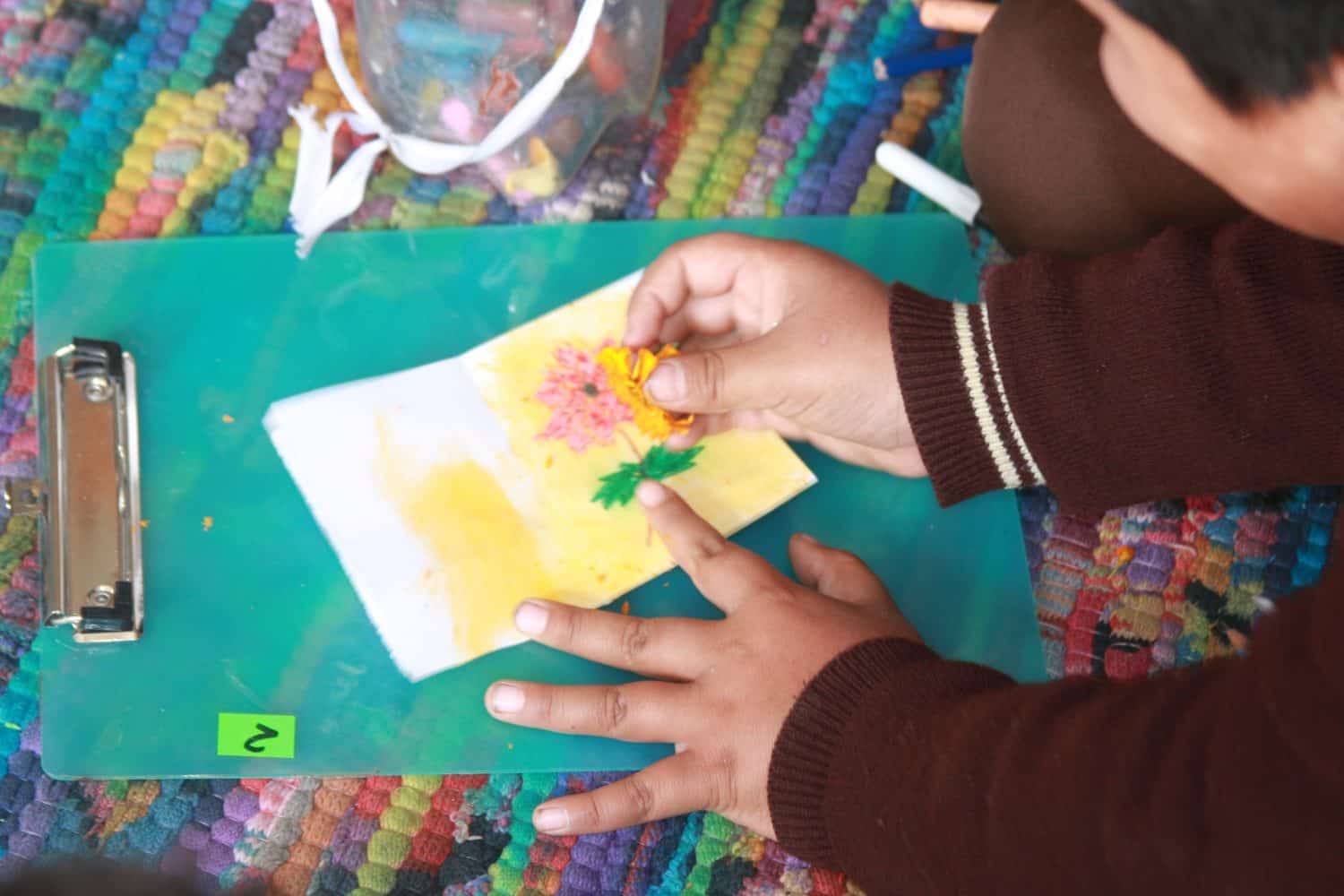 A young orphan child in Nepal learns to paint using natural color