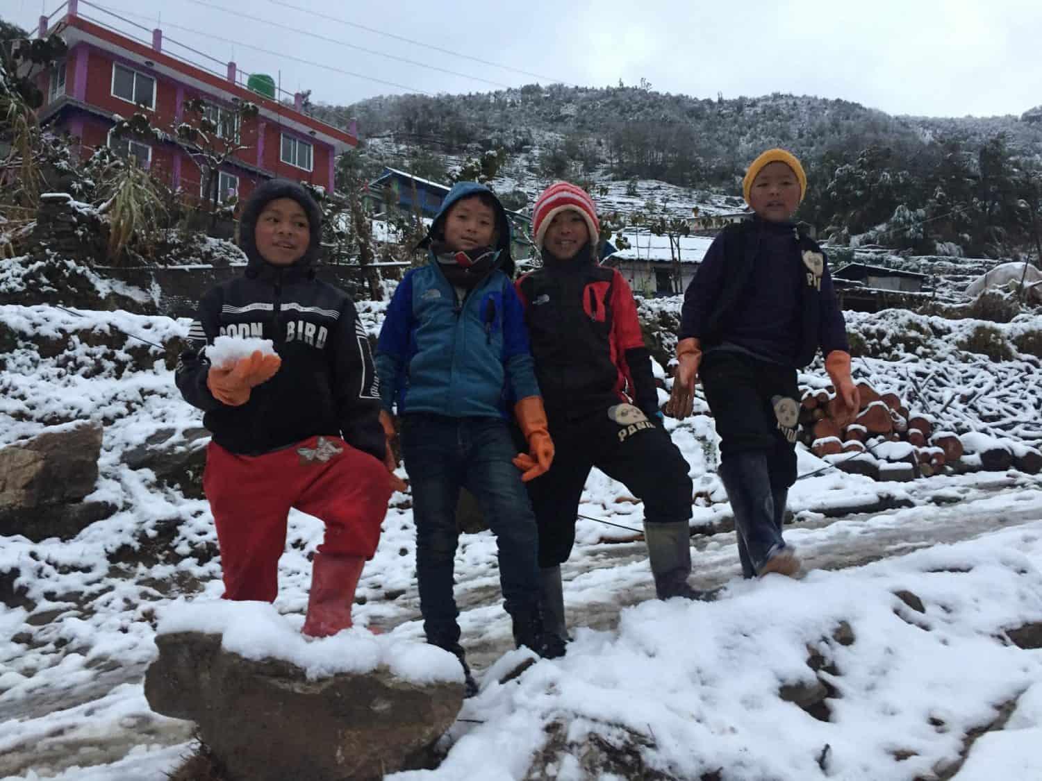 Four young Nepalese children playing in the snow in Ulleri