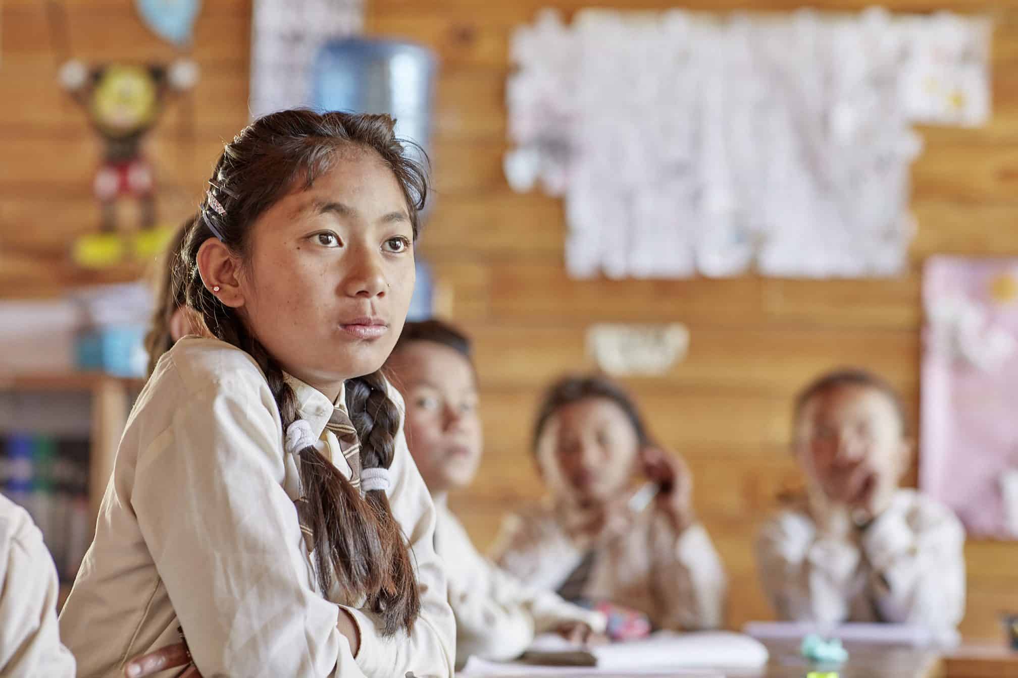 Nepalese student looks on with other students in the background at a Himalayan Life school
