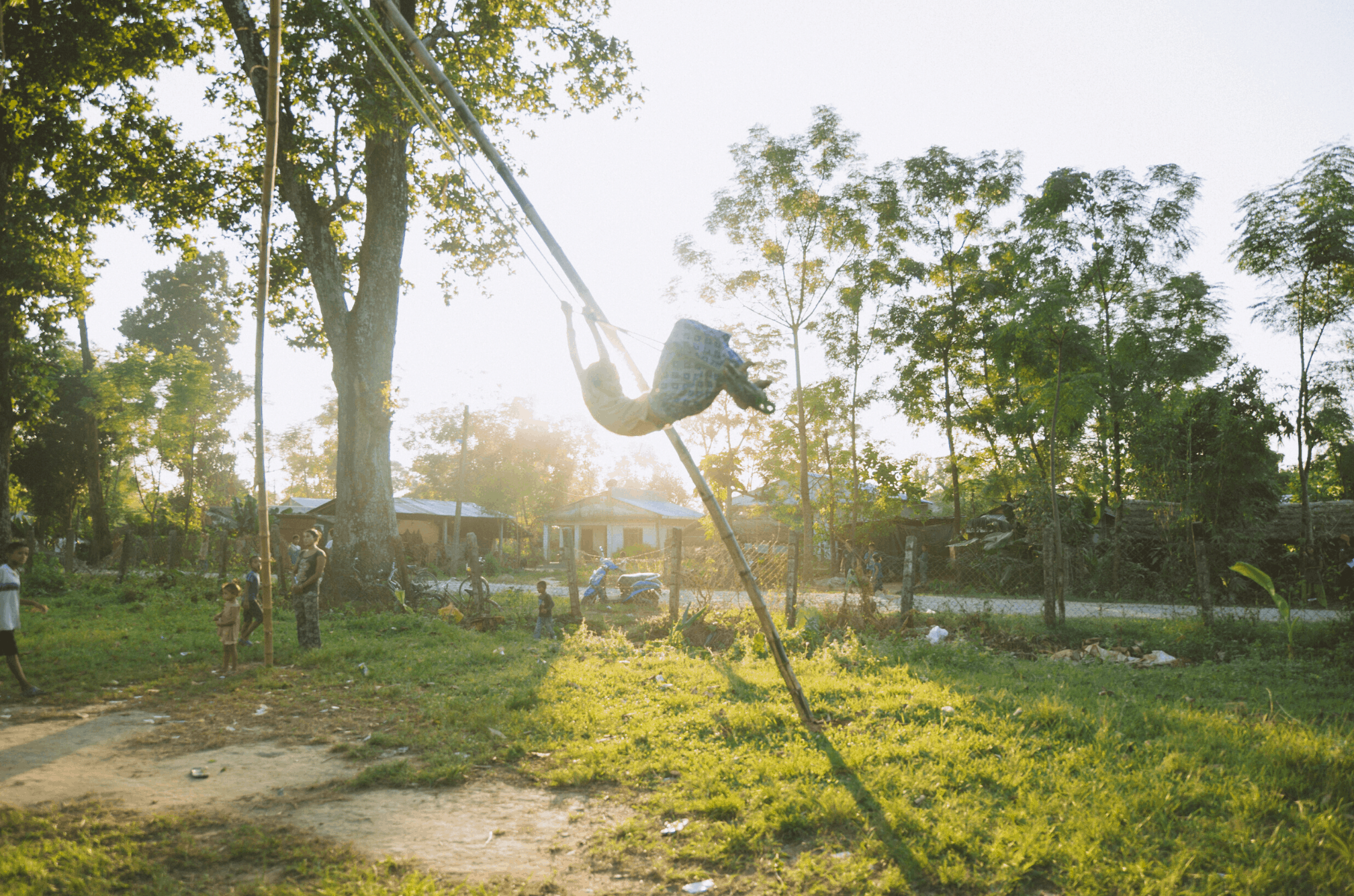 A girl swings on a Nepali swing in the jungles of Chitwan after playing hockey in Himalayan Life's program