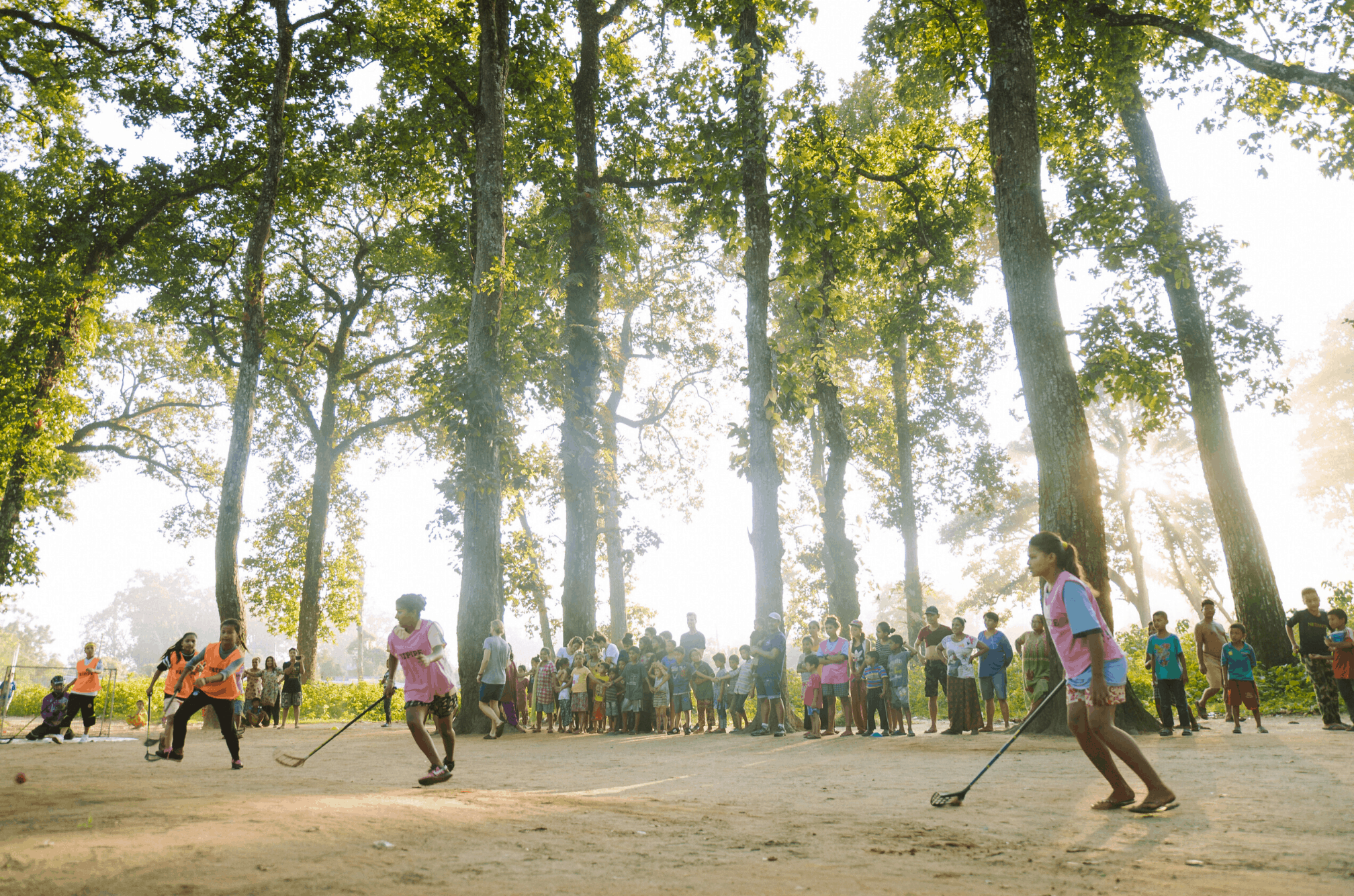 Children of the Himalayan Life Chitwan outreach hockey program play on a dirt field in the jungle of Southern Nepal
