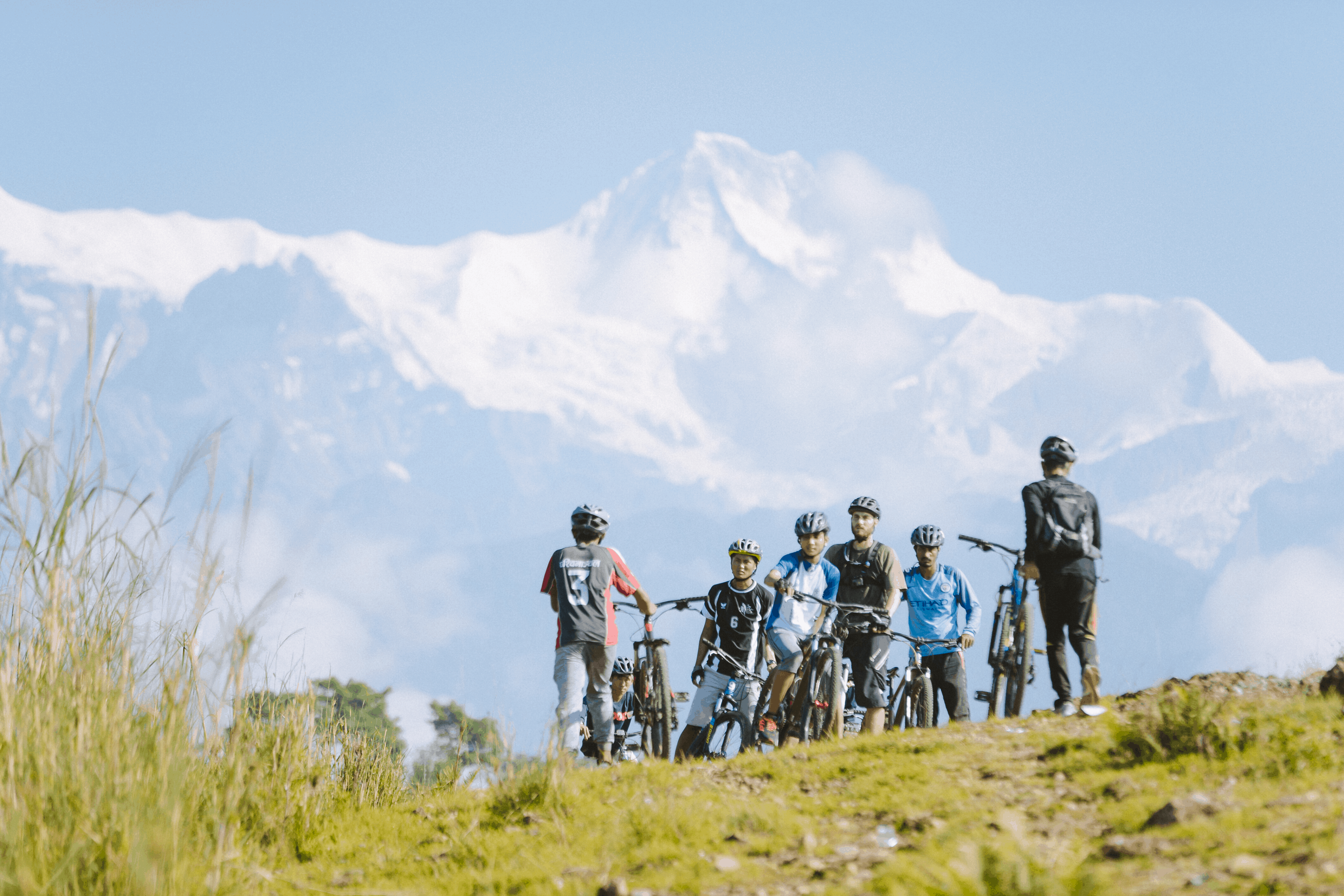 Boys from Himalayan Life's biking program sit at the foot of the Himalayas in Pokhara