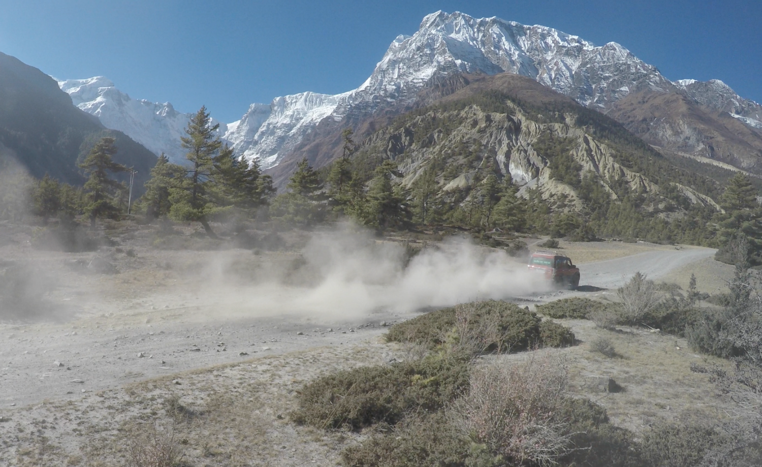 A 4x4 jeep picks up dust as it rips through the valley of the Himalayas on a Himalayan Life Adventures trip